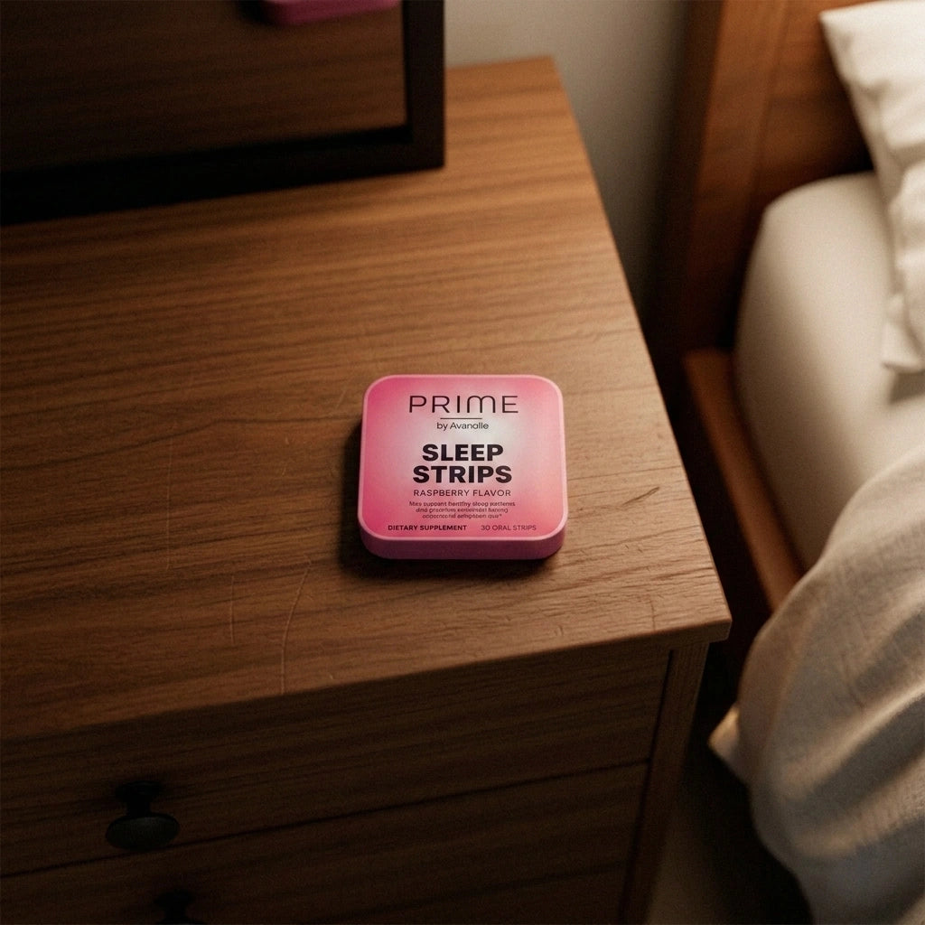 Pink container of Prime Sleep Strips on a wooden nightstand.