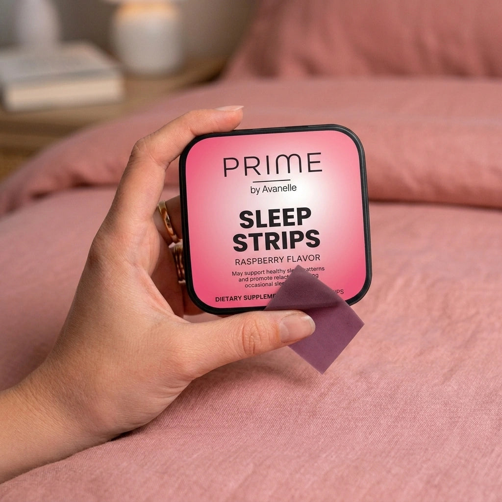 Hand holding a package of 'Prime by Avanelle Sleep Strips' on a pink surface.